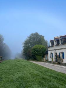 a house on a grassy hill next to a building at Ecluse de l'Ile in Carhaix-Plouguer +16 photos