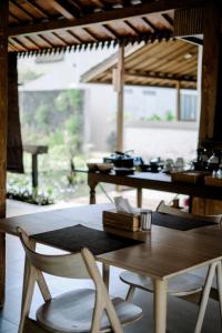 einen Esstisch und Stühle in einem Zimmer mit Aussicht in der Unterkunft Ijen Estate Resort And Villa in Dadapan