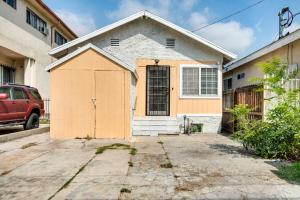 a house with a wooden garage in a driveway at Cozy Home - 2 Mi to Walk of Fame and Griffith Park! in Los Angeles