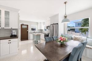 a kitchen and dining room with a wooden table and chairs at Super Snapper lux w/Heated Pool, Tiki, Dock, Lanai in Marathon
