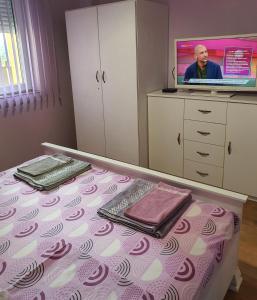 una camera con letto e lenzuola viola e bianche di Нощувки Краткосрочен наем a Plovdiv