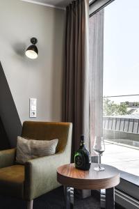 a living room with a chair and a table and a window at Hotel Ross in Schweinfurt