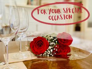 een boeket rode rozen op een tafel met wijnglazen bij Città Studi Apartment in Milaan