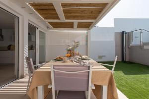 a dining room with a long table and chairs at Sunset in Maspalomas