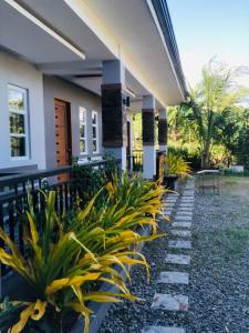 a house with a row of plants in front of it at RICHVILLE LITTLE BORACAY GUEST HOUSE in Calatagan