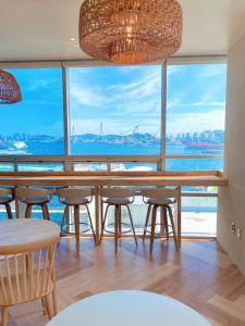 a dining room with a table and chairs and a large window at Stay Gaon in Busan