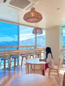 a woman sitting at a table in a restaurant at Stay Gaon in Busan