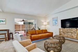 uma sala de estar com um sofá e uma televisão de ecrã plano em Trendy 4-Bedroom Heated Pool Car Near Beaches em Sarasota