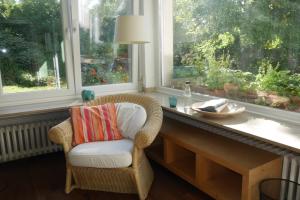 a wicker chair sitting next to a table in front of a window at Glück in Benrath in Düsseldorf