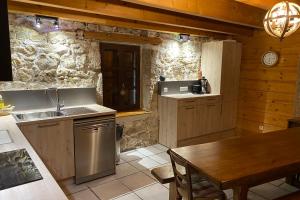 cocina con fregadero y mesa en una habitación en chalet Saint Joseph au coeur du massif de la Chartreuse !, en Saint-Christophe-sur-Guiers