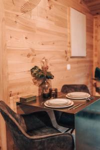 een eettafel met stoelen en een houten muur bij Wooden Nest in Durbuy