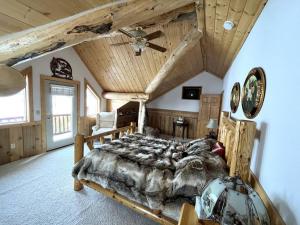 1 dormitorio con 1 cama grande y techo de madera en The Wyoming Lodge and Game Room, en Dubois