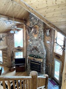 Cabaña de madera con sala de estar con chimenea de piedra. en The Wyoming Lodge and Game Room, en Dubois