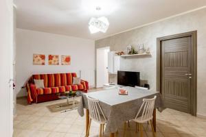 un soggiorno con tavolo e divano rosso di Casa Relax Salento - Relax House in the village a Specchia