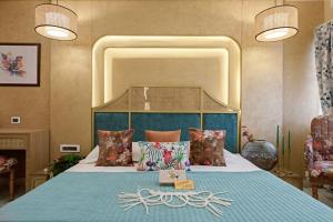 a bedroom with a large bed with a blue blanket at Hotel Sarang Palace - Boutique Stays in Jaipur