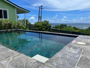 a swimming pool with a view of the ocean at Studio Blu at Waves Villa Guesthouse in Kingstown