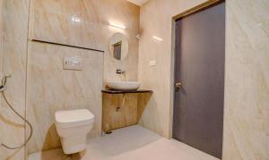 ein Bad mit einem WC, einem Waschbecken und einer Dusche in der Unterkunft FabHotel Premium Kashi in Varanasi