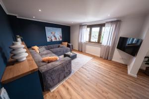 a living room with a couch and a television at Eifellodge - am roten Sandberg in Prüm