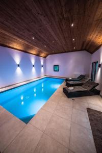 a swimming pool in a house with a wooden ceiling at Eifellodge - am roten Sandberg in Prüm