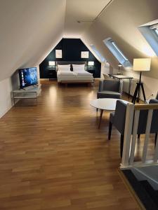 a attic living room with a bed and a tv at DK Hotel Deutscher Kaiser in Heidelberg
