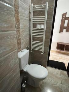 a bathroom with a white toilet in a room at Ваканционно селище Романтика in Kirkovo