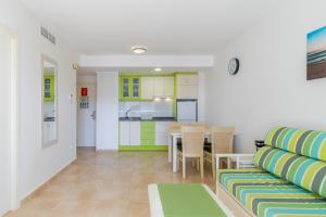 ein Wohnzimmer mit einem Tisch und Stühlen sowie eine Küche in der Unterkunft Esmeralda13 de Calpe in Calpe