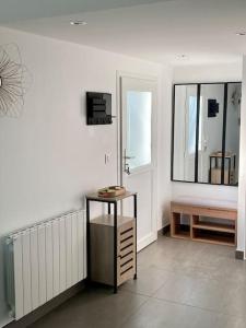 Zimmer mit einem Tisch, einer Bank und einem Spiegel in der Unterkunft Appartement cosy entre Genève et Annecy 