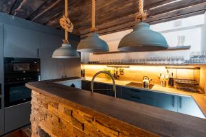 a kitchen with a counter and three pendant lights at Chalupa Na Pustinách in Jablonec nad Nisou