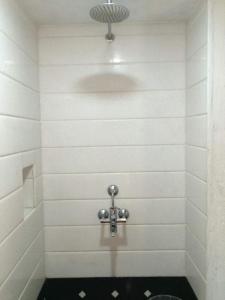 een badkamer met een toilet in een witte muur bij Karikkathi Beach House in Trivandrum