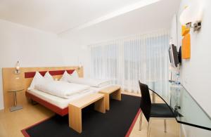 シュピーツにあるHotel Seasideのベッドルーム1室(ベッド1台、テーブル、椅子付)