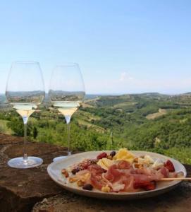 un piatto di cibo e due bicchieri di vino di Vinoteka Brda a Šmartno (San Martino)