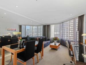 a living room with a couch and a table in a room at The Sebel Quay West Suites Sydney in Sydney