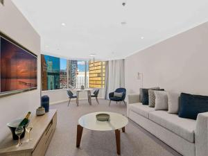 a living room with a couch and a table at The Sebel Quay West Suites Sydney in Sydney