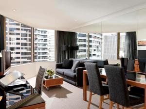 a living room with a couch and a table at The Sebel Quay West Suites Sydney in Sydney