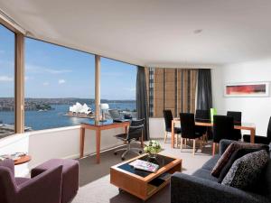 a living room with a view of the ocean at The Sebel Quay West Suites Sydney in Sydney