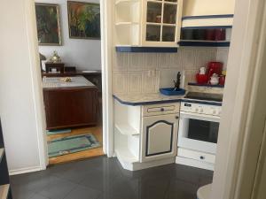 a small kitchen with white cabinets and a stove at Perfect Remote-Workplace in Sunny Apartment in Myślenice