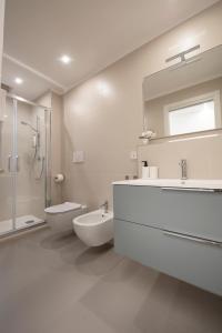 a white bathroom with two sinks and a shower at A casa di Fiore, holiday home in Giovinazzo