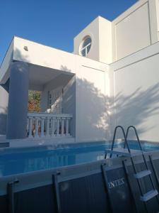 a villa with a swimming pool and a house at Paradiso Kallithea villa in Koskinou
