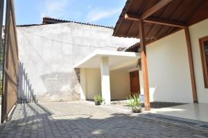 un patio de una casa con una pared de piedra en Kerinci Hill Holiday Home, Dago Golf (for families only), en Bandung