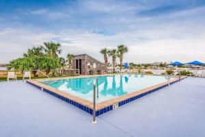 ペンサコーラにあるWalk to Florabama from Renovated Ground Floor 2Bd-2Ba with Pickleball, Boat Slipsの家屋を背景にした大型スイミングプール