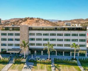 an office building with palm trees and mountains in the background at Gamma Los Cabos in San José del Cabo