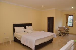 1 dormitorio con 1 cama, mesa y sillas en Kerinci Hill Holiday Home, Dago Golf (for families only), en Bandung