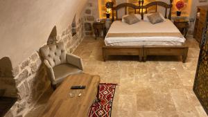 馬爾丁的住宿－Hanedan Konağı Butik Otel Deluxe King Bed Double Traditional Room Yukarıkır，一间卧室配有一张床、一把椅子和一张桌子