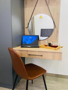 a laptop sitting on a desk with a mirror at Mayswood Self Catering Apartments in Gaborone