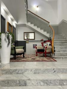 a living room with two chairs and a staircase at Siculea Home in Adrano