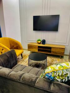 a living room with a couch and a flat screen tv at Mayswood Self Catering Apartments in Gaborone