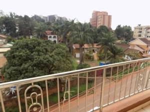 a balcony with a view of a city with palm trees at Comfort Silverline Apartments in Kampala