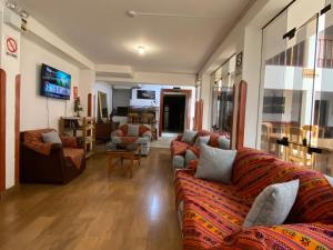 sala de estar con 2 sofás y TV en Hostal Saphi - Excelente ubicación, en Cusco
