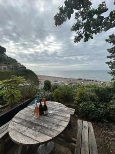 una mesa de picnic con tres botellas de vino. en Anchor Inn by Greene King Inns, en Beer