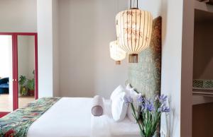 a bedroom with a white bed and a chandelier at Margot Old Tbilisi in Tbilisi City